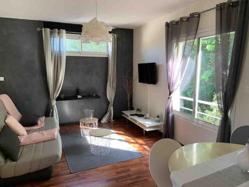 ein Wohnzimmer mit Sofa und Tisch in der Unterkunft T2 LA CIOTAT 60M2 AVEC TERRASSE EQUIPÉE in La Ciotat