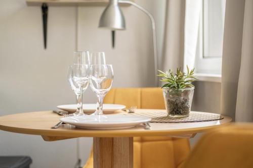 - une table avec des verres à vin et une plante en pot dans l'établissement Le Petit Vauban, à Strasbourg