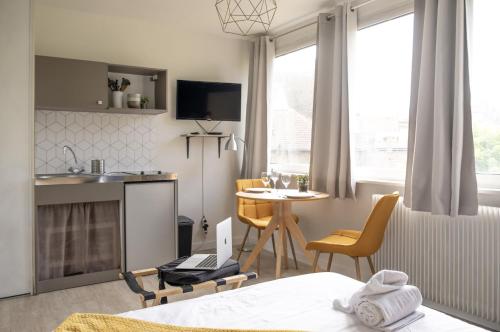 une chambre avec un lit et une table et une cuisine dans l'établissement Le Petit Vauban, à Strasbourg