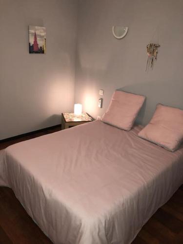 - une chambre dotée d'un lit blanc avec deux oreillers et une table dans l'établissement T2 LA CIOTAT 60M2 AVEC TERRASSE EQUIPÉE, à La Ciotat