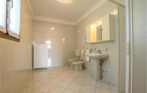 アルバレッラ島にあるStunning Home In Albarella Ro With 3 Bedrooms And Outdoor Swimming Poolの白いバスルーム(トイレ、シンク付)