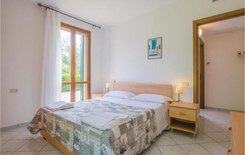 アルバレッラ島にあるStunning Home In Albarella Ro With 3 Bedrooms And Outdoor Swimming Poolのベッドルーム(大型ベッド1台、窓付)