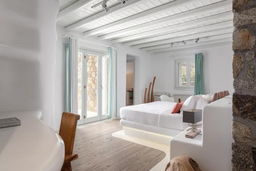 a white room with two beds and a couch at El Sueno Villa Mykonos in Kalafatis