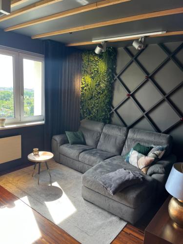 a living room with a gray couch and a table at Apartament z widokiem - BlaBlaFlat Szczecin Santocka in Szczecin