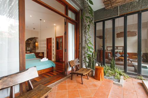 a bedroom with a bed and a bench on a patio at Chaca Beach House in Da Nang