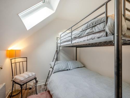 a bedroom with a bunk bed and a window at Millport Bay View in Millport