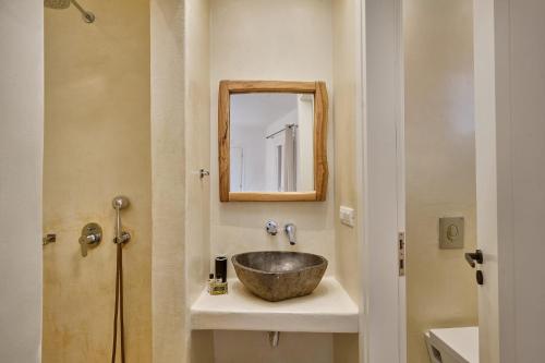 a bathroom with a bowl sink and a mirror at Casa Philippi Suites in Mikonos