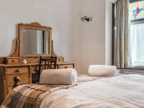 Schlafzimmer mit einem Bett, einer Kommode und einem Spiegel in der Unterkunft Melrose in Clitheroe