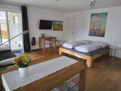 a living room with a bed and a table at Ferienwohnung im Weinbergweg in Ravensburg