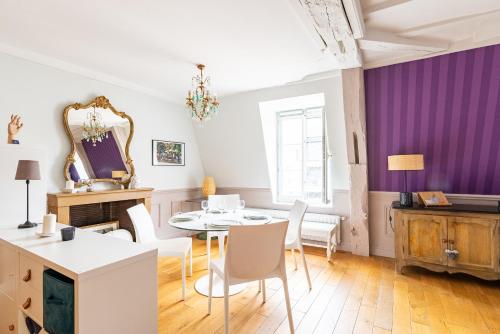une salle à manger avec des murs violets, une table et des chaises dans l'établissement Le Lilas - Hypercentre Confort Calme 4 voyageurs, à Dijon