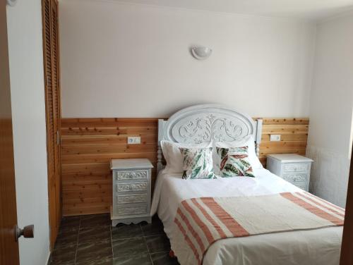 1 dormitorio con 1 cama con cabecero blanco en CASA 25, en Conceição