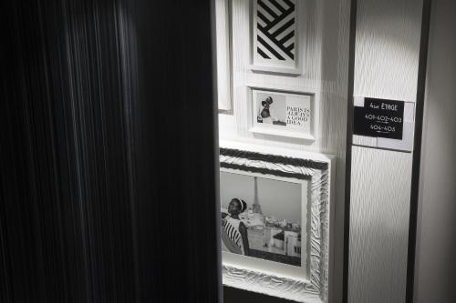 a mirror in a room with a picture on the wall at Hotel Ekta Champs Elysées in Paris