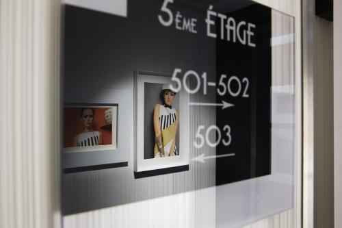 a display case with three pictures on a wall at Hotel Ekta Champs Elysées in Paris