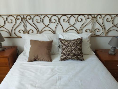 un letto bianco con due cuscini sopra di CASA 25 a Conceição