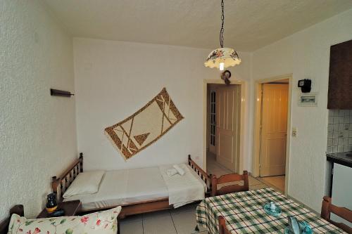 a bedroom with a bed and a table and a chandelier at Villa Aristea in Kalo Chorio