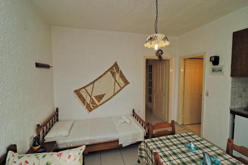 una camera con letto, tavolo e lampadario a braccio di Villa Aristea a Kalo Chorio