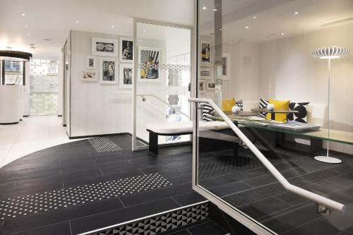 a bathroom with a glass shower with a bench at Hotel Ekta Champs Elysées in Paris