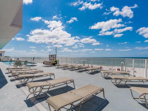 a row of benches sitting on a patio overlooking the ocean at Windemere #1104 in Perdido Key