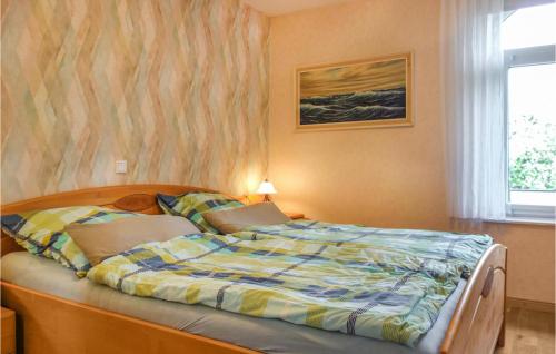a bedroom with a bed with a striped comforter at Cozy Apartment In Wurster Nordseekste With Wifi in Hofe