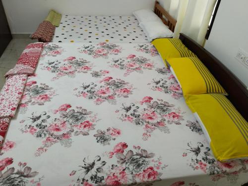 Una cama con colcha floral. en Tirunelveli Home Stay, en Tirunelveli