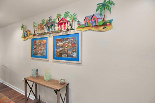 a wall with three pictures of houses and a table at Club at Mexico Beach 2E by Pristine Properties Vacation Rentals in Mexico Beach