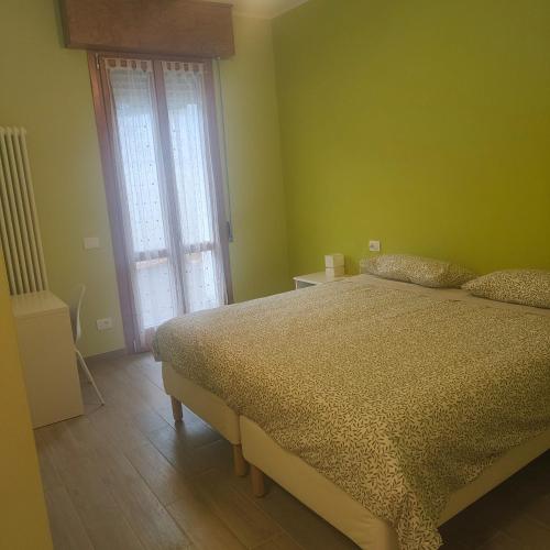 1 dormitorio con cama y ventana grande en B&B Canossalpaca, en Canossa