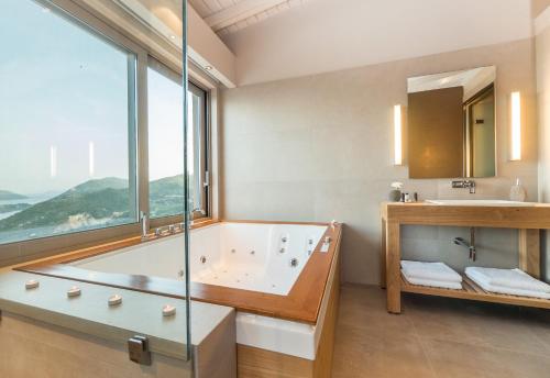 a bathroom with a tub and a sink and a window at Callista in Palaiokhóri