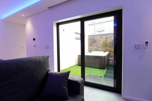a living room with a couch and a sliding glass door at Dainty House in Ovar