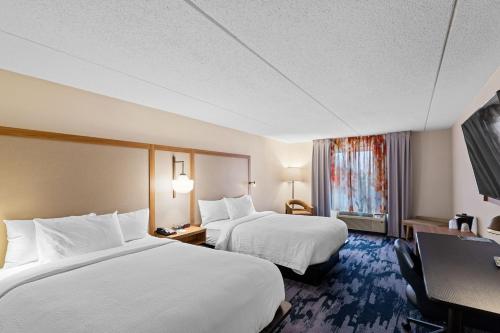 a hotel room with two beds and a desk at Fairfield Inn by Marriott Evansville West in Evansville