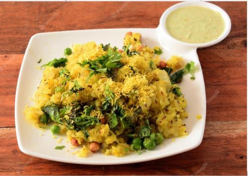 a plate of scrambled eggs with peas and a sauce at Hotel Galaxy Opp Surat Railway Station in Surat