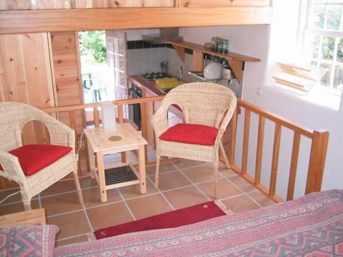 a living room with two chairs and a table at O Palheiro in Faja Grande