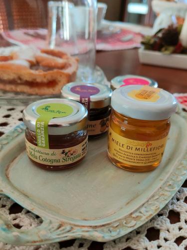 three jars of honey on a plate on a table at Le Piracante in Caiazzo