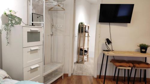 una camera da letto con cassettiera e scrivania con televisore di Barcelona Park Güell Estudio a Barcellona