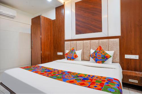 ein Schlafzimmer mit einem Bett mit einer bunten Decke darauf in der Unterkunft FabHotel Coral in Indore