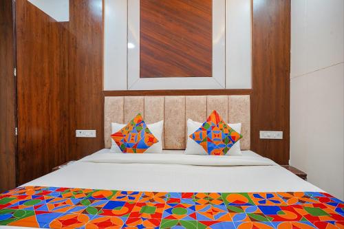 ein Schlafzimmer mit einem Bett mit einer bunten Bettdecke in der Unterkunft FabHotel Coral in Indore