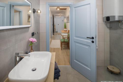baño con lavabo blanco y puerta en Family Vacation Villa, en Žbandaj