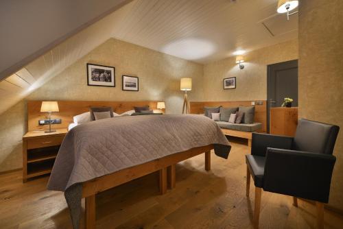 a bedroom with a large bed and two chairs at Rezidence Pihel in Nový Bor