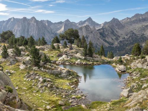 a lake in the middle of a mountain range at Hotel Estanys Blaus in Tavascan