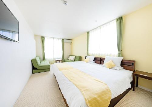 a bedroom with a large bed and a television at Ecot Shimozato 3 in Miyako Island