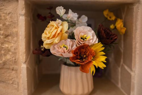 Un vaso bianco con un mazzo di fiori dentro. di Amélie Casa Vacanze a Santa Croce Camerina