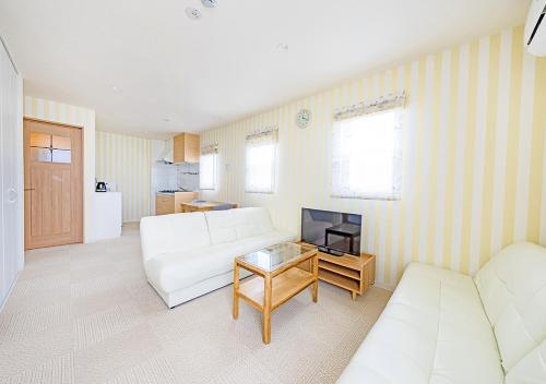 a living room with a white couch and a tv at Ecot Shimozato 3 in Miyako Island