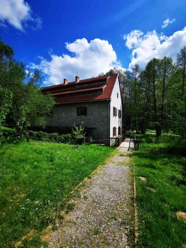a building with a red roof on a grass field at Chilling On Orfű Apartman in Orfű