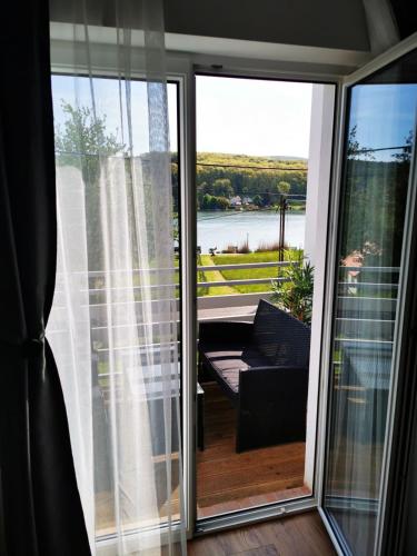 a sliding glass door with a view of a balcony at Chilling On Orfű Apartman in Orfű