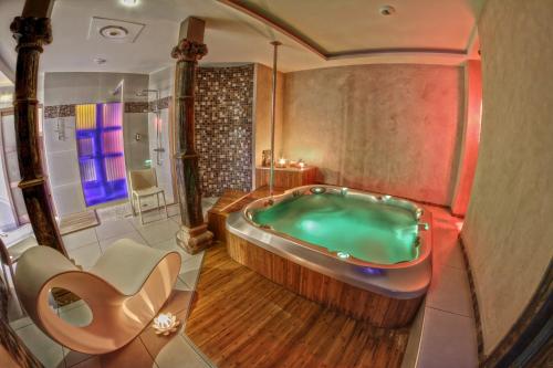 uma casa de banho com uma banheira no meio em kiné lounge em Bazet