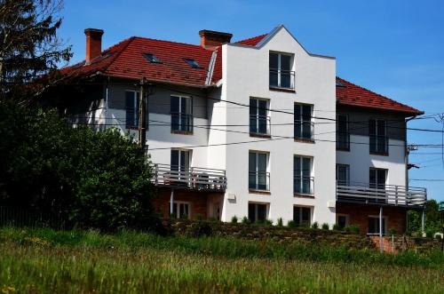 una gran casa blanca con techo rojo en Chilling On Orfű Apartman en Orfű