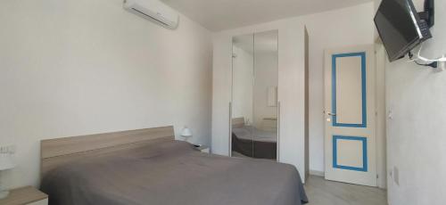 a bedroom with a bed and a flat screen tv at Dimore Dell'Isola Rossa in Isola Rossa