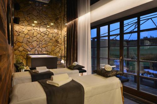 a spa room with three beds and a large window at Rezidence Pihel in Nový Bor