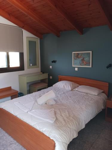 a bedroom with a large bed with white sheets at Soulis Hotel in Arkoudi