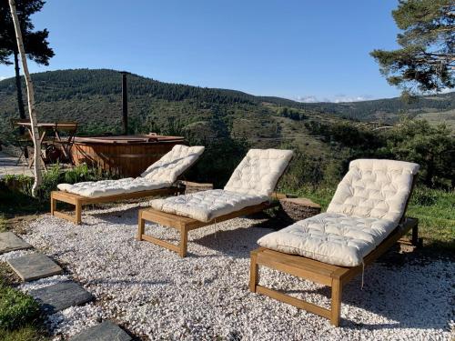 een groep van drie ligstoelen bovenop een heuvel bij Minds & Mountains Eco Lodge in La Molina