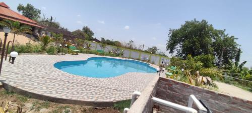 a swimming pool in front of a building at Vrundavan home stay and Village resort in Kevadia